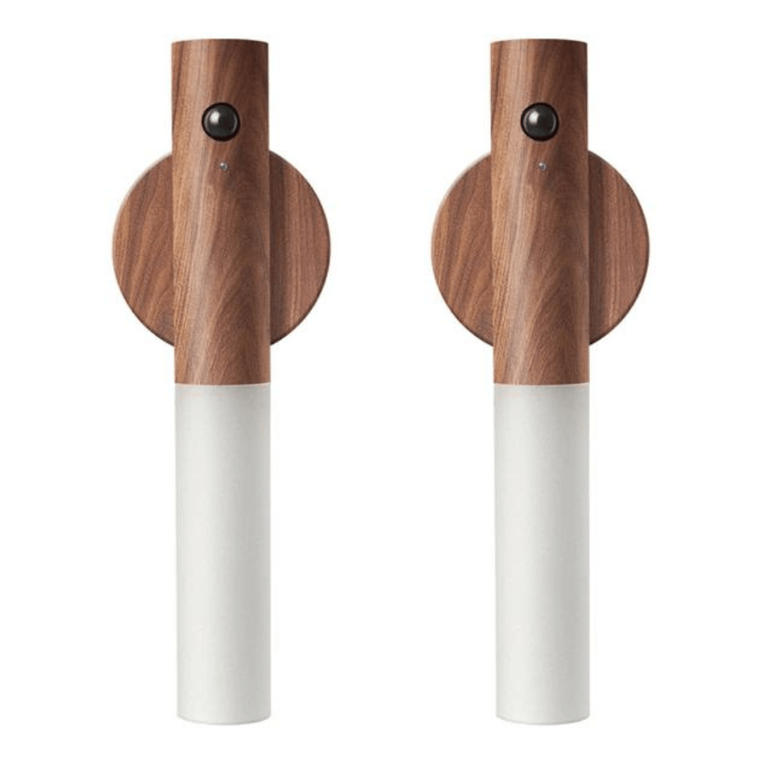 Two wooden pepper mills with white bases on a white background