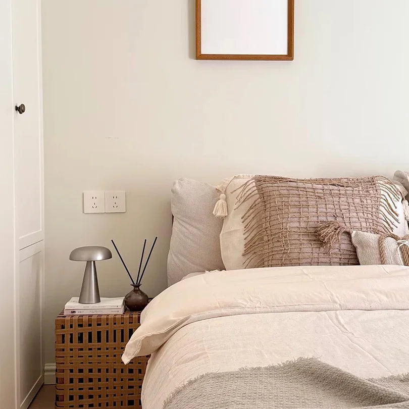 Neatly made bed with decorative pillows in a bedroom setting.