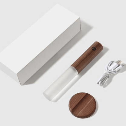 Wooden and white handheld device with a cord on a white background